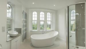 a white bathroom with a tub and a shower at Carlogie House in Carnoustie +29 photos