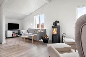 a living room with a couch and a fireplace at LN2048-Hjorring-Havmanden-6 in Kærsgård Strand
