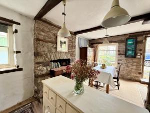 a kitchen with a table with a vase of flowers at Half Moon House in Hay-on-Wye