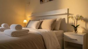 a bedroom with a white bed with towels on it at Kalamata Deluxe Suite By AGGELOS in Kalamata