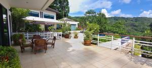 a balcony of a house with a table and chairs at Unique panoramic sea view pool villas in Phuket