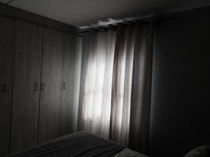 a bedroom with a bed and a window with curtains at Zoe in Centurion