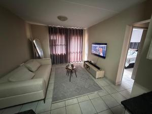 a living room with a couch and a tv at Zoe in Centurion +3 photos