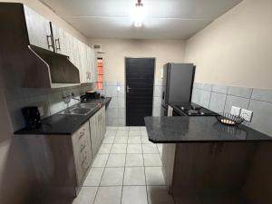 a kitchen with a sink and a refrigerator at Zoe in Centurion