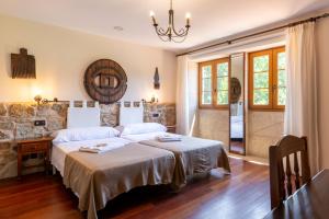 a bedroom with a bed and a table and windows at Casa de Trillo Galitrips in Rego de Santa Marina