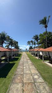a row of houses with palm trees and a pathway at Pousada Holy Salt Cumbuco in Caucaia