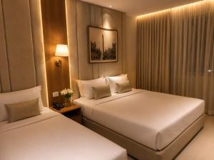 a hotel room with two beds and a window at Royal Town Hotel in Cairo