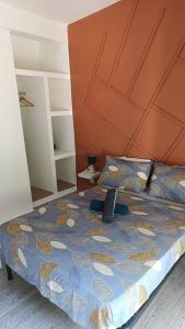 a bed with a blue comforter with a laptop on it at Le Mäysa dzindzano Residence in Sada