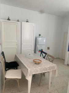 a table and chairs in a room with a refrigerator at Nadia Babay in Dar Salah Bey