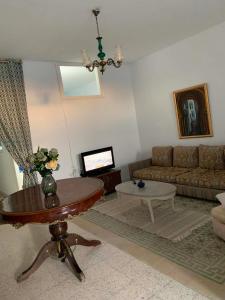 a living room with a couch and a table at Nadia Babay in Dar Salah Bey