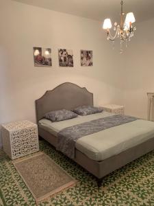 a bedroom with a bed and a chandelier at Nadia Babay in Dar Salah Bey