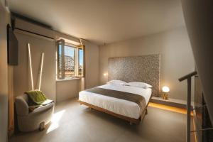 a bedroom with a bed and a chair and a window at Dimora Guidi Tordini in Grottammare