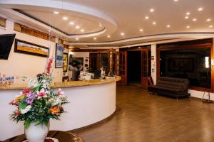 a lobby with a counter with a vase of flowers at Hotel PUENTE PIEDRA PARK in Villa de Leyva