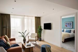 a living room with a couch and a bed and a mirror at Cove Landmark Pinnacle in London +16 photos
