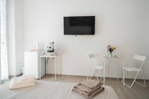 a living room with two chairs and a tv on a wall at 3Season Ortona B&B in Ortona