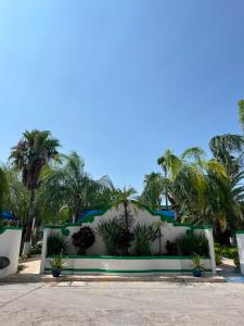 a building with palm trees in the background at Hotel Virrey in Reynosa