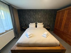 a bedroom with a large bed with two towels on it at L'Aurore Céleste in Aywaille