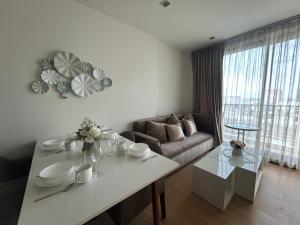a living room with a table and a couch at The Astra Residence in Chiang Mai