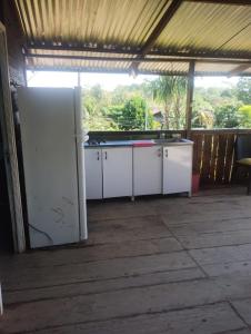 an outdoor kitchen with white appliances in a building at Cabaña Murringo a dos minutos en coche de Necobotes en Necoclí in Necoclí