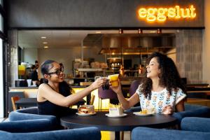 two women sitting at a table with drinks at Moxy Atlanta Downtown in Atlanta
