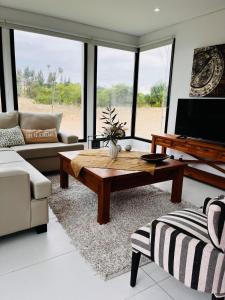 a living room with a couch and a coffee table at COSTA ESMERALDA S3 para 10 pileta y jardín privados in Pinamar