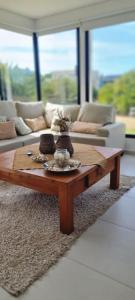 a coffee table in a living room with a couch at COSTA ESMERALDA S3 para 10 pileta y jardín privados in Pinamar +25 photos