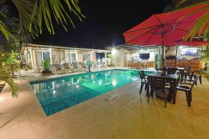 a swimming pool with chairs and a table with an umbrella at Majestic Sands in San Carlos