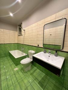 a green tiled bathroom with a toilet and a sink at Nia The Nest in Nafpaktos +49 photos
