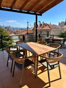 a wooden table and chairs on a balcony at Nia The Nest in Nafpaktos