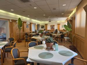 a restaurant with tables and chairs in a room at Plaza Hotel Gyula in Gyula