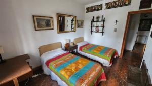 a bedroom with two beds and a cross on the wall at Campoarique in Tudela de Duero +10 photos