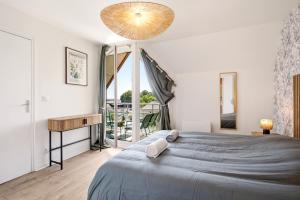 a bedroom with a large bed and a large window at Le Calmette - Balcon, Parking & Ascenseur in Caen