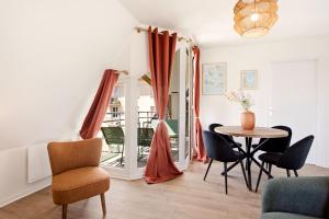a living room with a table and chairs at Le Calmette - Balcon, Parking & Ascenseur in Caen