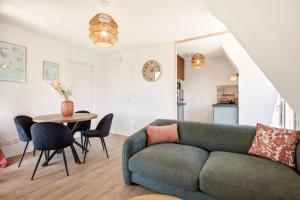a living room with a couch and a table at Le Calmette - Balcon, Parking & Ascenseur in Caen +12 photos
