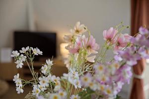 a bunch of pink and white flowers in a vase at Le Calmette - Balcon, Parking & Ascenseur in Caen