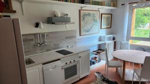 a kitchen with white appliances and a table and a window at Campoarique in Tudela de Duero