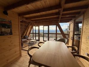 a table and chairs in a room with a large window at Monte Waïa in Guasca