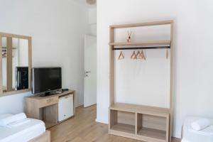 a living room with a television and a mirror at B&B Sunny Side in Sarandë