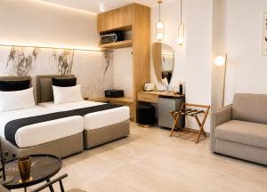 a bedroom with a bed and a couch and a chair at Casa Enetiko in Chania
