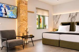 a bedroom with a bed and a table and a chair at Casa Enetiko in Chania