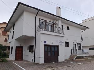 a white building with two doors and a balcony at Villa Afrodita in Ohrid