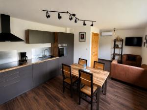 a kitchen and dining room with a wooden table and chairs at Le Cabanon de LaFermeDuNol in La Bresse