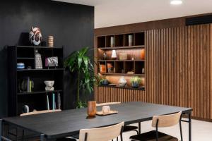 a dining room with a black table and chairs at Cove Landmark Pinnacle in London