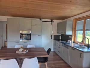a kitchen with a table and chairs in a room at Bereuter in Sibratsgfäll