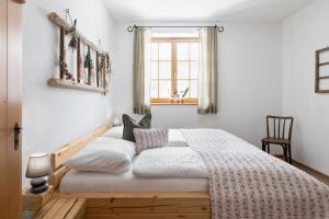 a bedroom with a bed with white sheets and a window at Sloho Bergurlaub - Adults Only in Hohentauern +87 photos