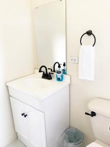 a bathroom with a sink and a mirror at The Vista Inn Studio #4 in Falmouth +2 photos