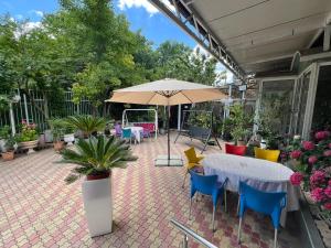 a patio with a table and chairs and an umbrella at Hotel Kamelia in Varna City +52 photos