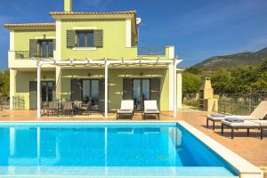 a villa with a swimming pool in front of a house at Villa Dora in Kefallonia
