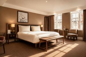 a hotel room with a bed and a chair at The May Fair Hotel, Mayfair, London in London