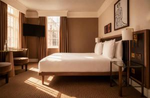 a hotel room with a bed and a desk at The May Fair Hotel, Mayfair, London in London